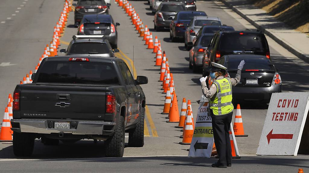 Fahrzeuge stehen vor dem Dodger Stadium in Los Angeles für einen Coronavirus-Test in einer Schlange. Foto: Mark J. Terrill/AP/dpa