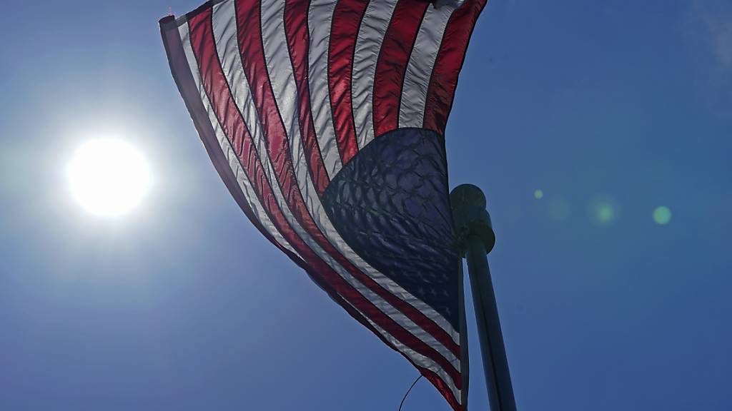 ARCHIV - Eine US-Flagge weht  mit der Sonne im Hintergrund in der Innenstadt von Seattle. Foto: Ted S. Warren/AP/dpa