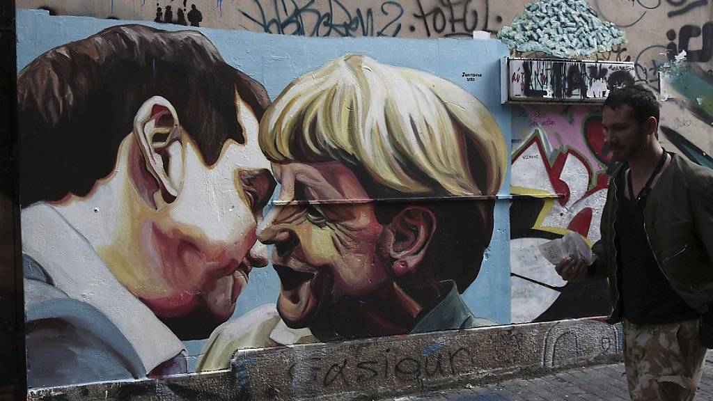 Ein Mann geht in Athen an einem Graffiti vorbei, das den griechischen Premierminister Alexis Tsipras und Angela Merkel, Kanzlerin von Griechenland-Gläubiger Deutschland, zeigt.