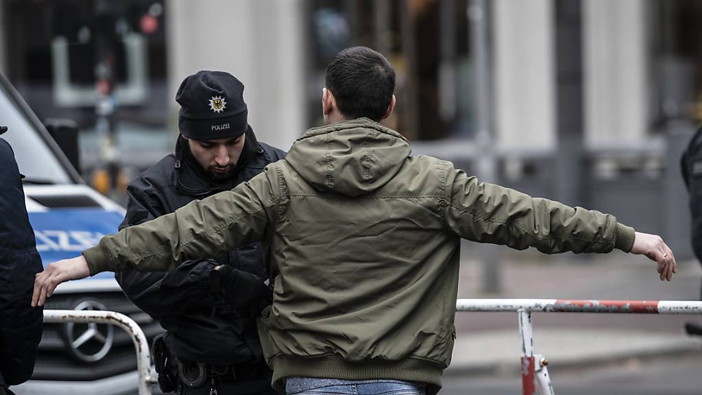 Libyen-Konferenz unter strengsten Sicherheitsvorkehrungen: Ein Polizist kontrolliert einen Passanten auf dem Potsdamer Platz in Berlin.