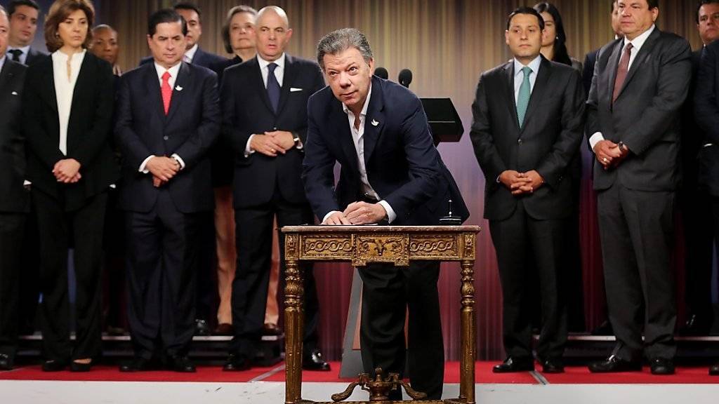 Kolumbiens Präsident Juan Manuel Santos unterschreibt den Antrag für ein Referendum über ein Friedensabkommen mit der FARC. (Archivbild)