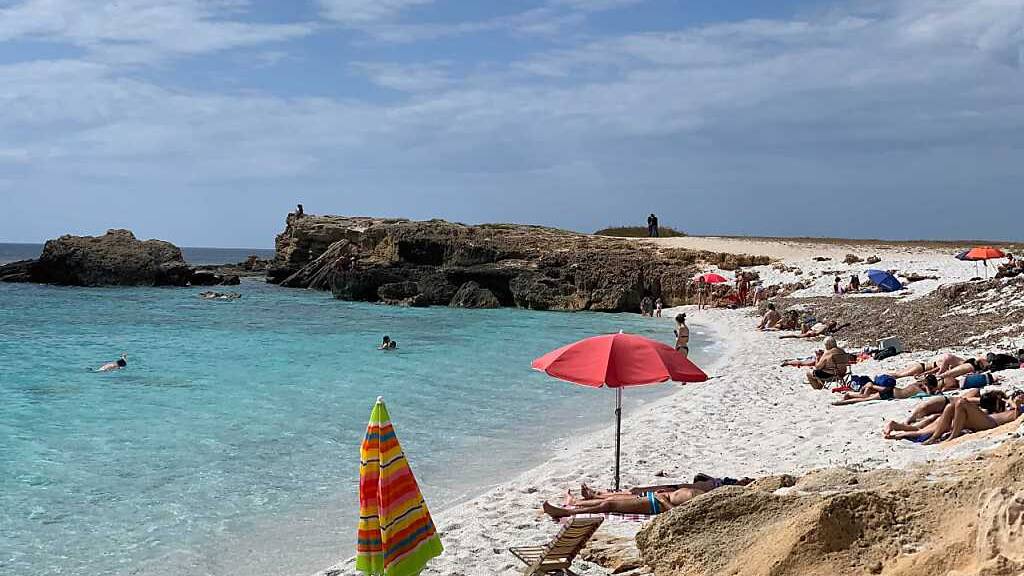 ARCHIV - Menschen liegen am Strand von Is Arutas an der Westküste Sardiniens. Urlauber und Bewohner in Italien müssen sich in den kommenden Tagen auf extreme Hitze einstellen. Für Dienstag und Mittwoch gab das Gesundheitsministerium am Montag für einige Teile Italiens die höchste Hitze-Stufe drei heraus. Foto: Annette Reuther/dpa - ACHTUNG: Verwendung nur im vollen Format