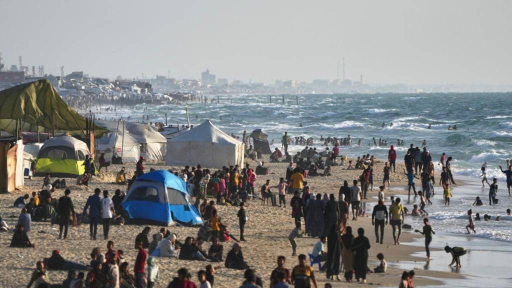 ARCHIV - Palästinenser versammeln sich in einem behelfsmäßigen Zeltlager für vertriebene Palästinenser am Strand von Muwasi, westlich von Khan Younis im Gazastreifen. Foto: Abdel Kareem Hana/AP/dpa