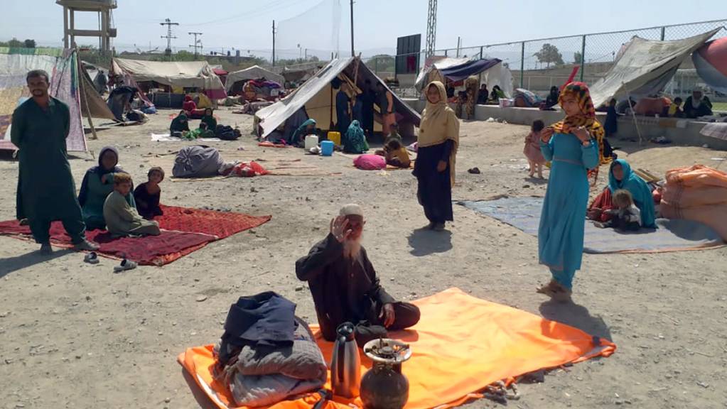 Afghanische Familien sitzen vor ihren Zelten am Rande von Chaman, einer Grenzstadt in der südwestlichen pakistanischen Provinz Belutschistan. Foto: Jafar Khan/AP/dpa