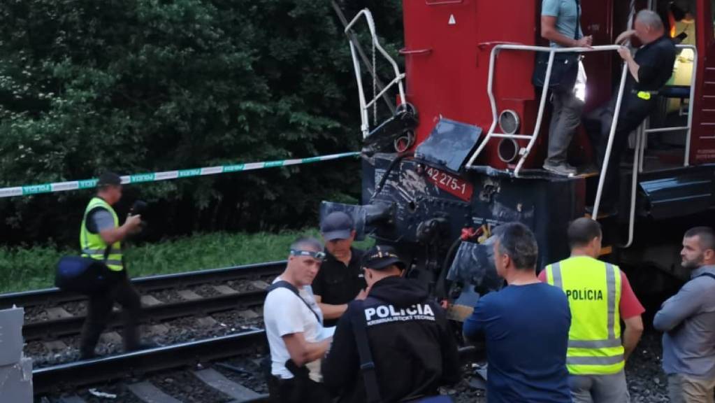 Polizisten stehen am Ort des Zugunglücks. Beim Zusammenstoss eines Personenzuges mit einer Lokomotive sind in der Slowakei viele Menschen verletzt worden.