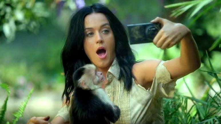 Katy Perry fotografiert sich mit einem Smartphone im Dschungel.