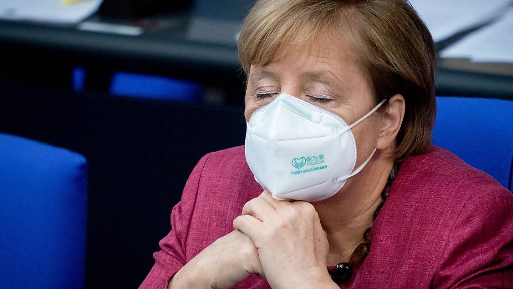 Bundeskanzlerin Angela Merkel (CDU) verfolgt mit geschlossenen Augen und Mund-Nasenbedeckung die Sitzung des Bundestages. Sie hatte vorher eine Regierungserklärung zur Bewältigung der Corona-Pandemie abgegeben.