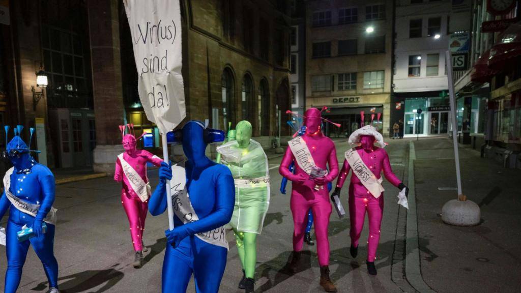 Eine als Virus verkleidete Gruppe marschiert zum nicht stattfindenden Morgestraich durch die Stadt Basel. (KEYSTONE/Georgios Kefalas)