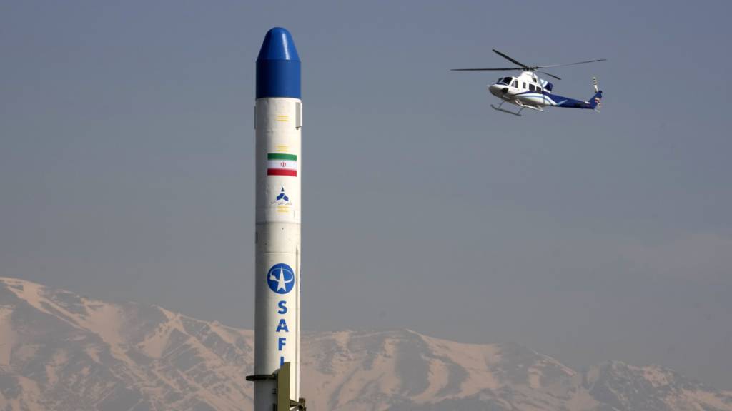 ARCHIV - Ein Hubschrauber fliegt über einen iranischen Satellitenträger. Foto: Vahid Salemi/AP/dpa