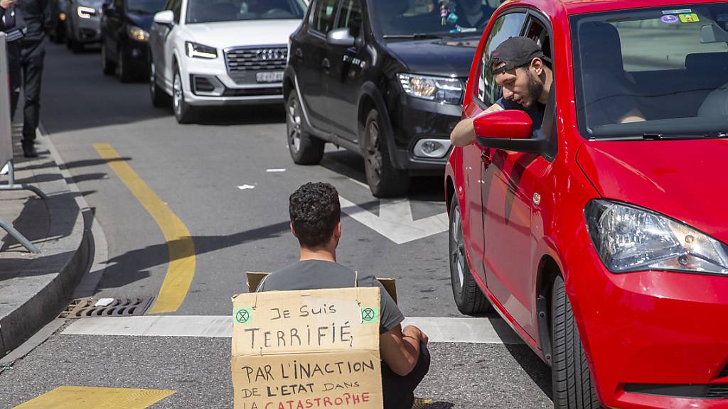 «Ich bin entsetzt über die Untätigkeit des Staates in der ökologischen Katastrophe», stand auf dem Plakat eines Aktivisten, der sich am Samstag in Genf auf die Strasse setzte.