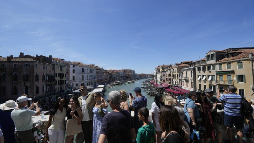 ARCHIV - Viele Touristen stehen auf der Rialto-Brücke in Venedig. Foto: Luca Bruno/AP/dpa
