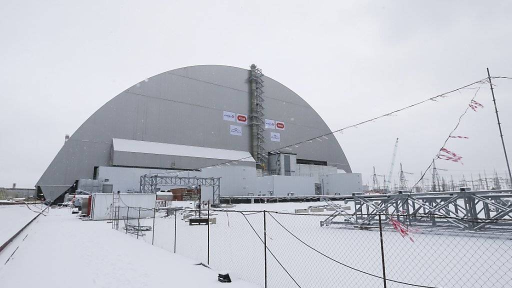 Die neue Schutzhülle um die Atomruine in Tschernobyl steht. Sie wurde mit einem Hydrauliksystem auf Spezialschienen über den havarierten Reaktor geschoben.