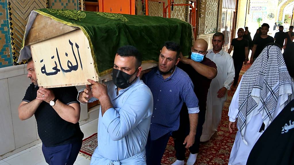 Trauernde tragen den Sarg eines Corona-Patienten, der bei der Explosion im Al-Khatib-Krankenhaus ums Leben kamen. Foto: Anmar Khalil/AP/dpa