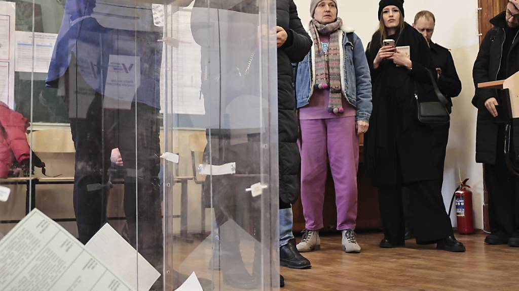 Wähler stehen an, um ihre Stimmzettel während der Präsidentschaftswahl in der pazifischen Hafenstadt Wladiwostok abzugeben. Foto: Uncredited/AP