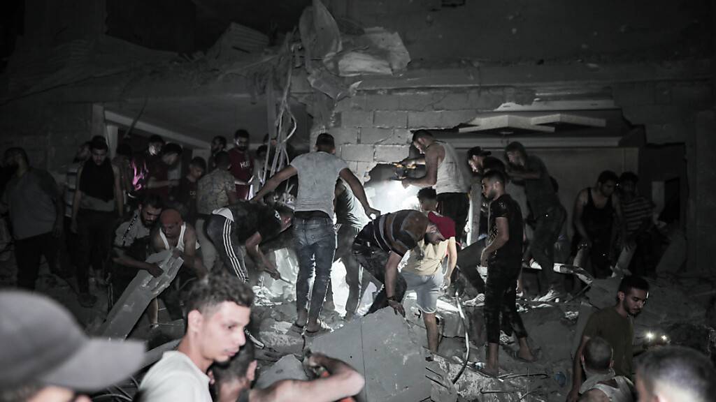 Bewohner des Flüchtlingslagers Al-Magasi suchen nach Überlebende in den Trümmern eines zerstörten Gebäudes. Foto: Adel Al Hwajre/IMAGESLIVE via ZUMA Press Wire/dpa