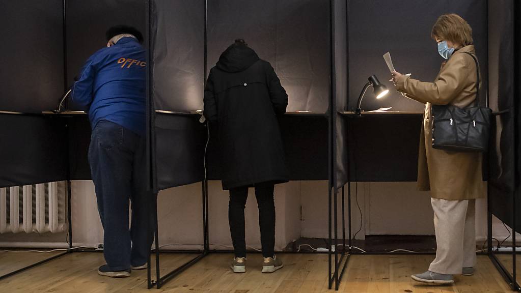 Wähler geben ihre Stimmen in Wahlkabinen ab. Foto: Mindaugas Kulbis/AP/dpa
