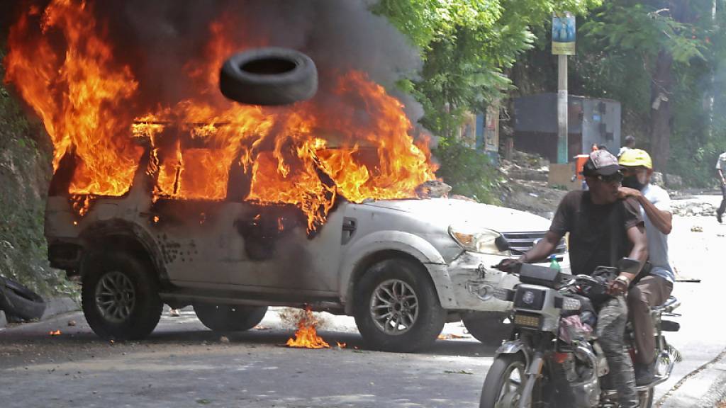 während einer Demonstration gegen die Unsicherheit in Port-au-Prince ist ein Auto angezündet worden. Foto: Odelyn Joseph/AP/dpa