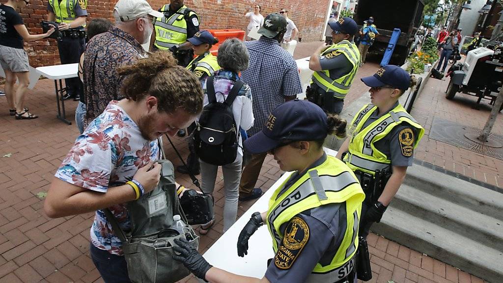 Die Polizei in Charlottesville kontrolliert Taschen. Zum Jahrestag der tödlichen Ausschreitungen an diesem Sonntag haben die Stadt Charlottesville und der Bundesstaat Virginia aus Sorge vor neuen Zwischenfällen den Notstand ausgerufen.