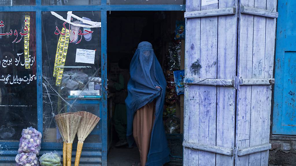 Eine afghanische Frau, die eine Burka trägt, verlässt einen kleinen Laden in Kabul. Bislang haben die Islamisten seit der Machtübernahme Mitte August die Rechte von Frauen wieder deutlich eingeschränkt. Foto: Petros Giannakouris/AP/dpa