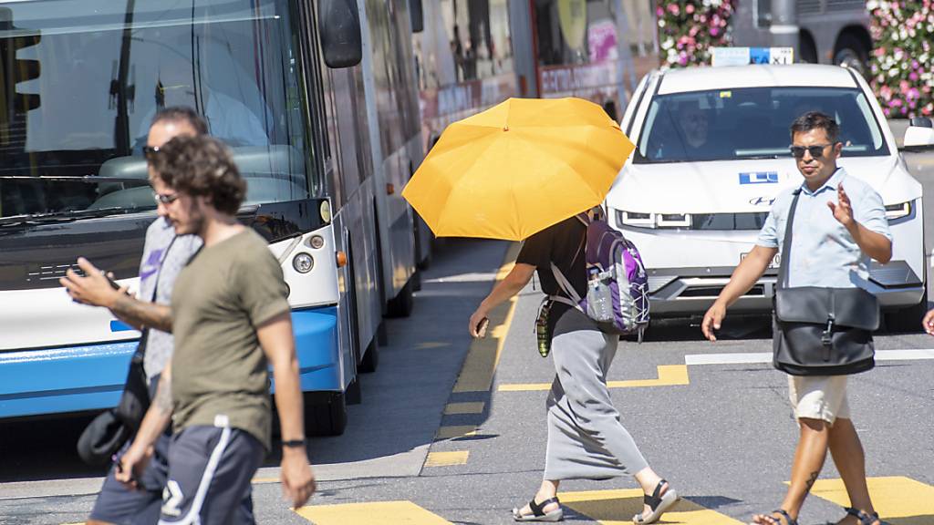 Die Menschen haben sich während der Hitzewelle mit Schirmen vor der Sonne und Hitze zu schützen versucht.