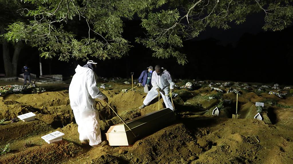 Friedhofsarbeiter in Sao Paulo begraben einen Menschen, der an Komplikationen im Zusammenhang mit Covid-19 gestorben ist. Foto: Nelson Antoine/AP/dpa