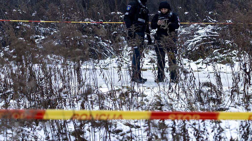Polizisten bewachen einen Bereich in der Nähe der Stelle, an der ein DHL-Frachtflugzeug in ein Haus nahe der litauischen Hauptstadt Vilnius gestürzt ist. Foto: Mindaugas Kulbis/AP