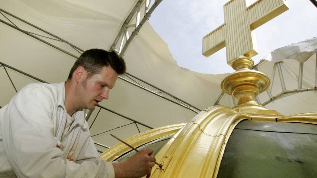 Das mit Gold verzierte Kreuz auf der Kuppel des Bundeshauses während der Renovation 2007. (Archivbild)