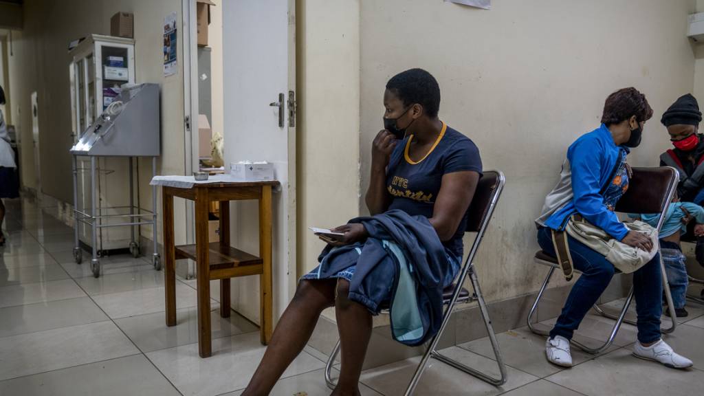 Menschen warten in der Hillbrow Clinic in Johannisburg auf eine Impfung gegen das Coronavirus. Nach Angaben der Weltgesundheitsorganisation WHO vom Donnerstag scheint eine Infektion mit der neuen Coronavirus-Variante Omikron in Südafrika nicht so häufig zu schwereren Krankheitsverläufen zu führen. Foto: Shiraaz Mohamed/AP/dpa