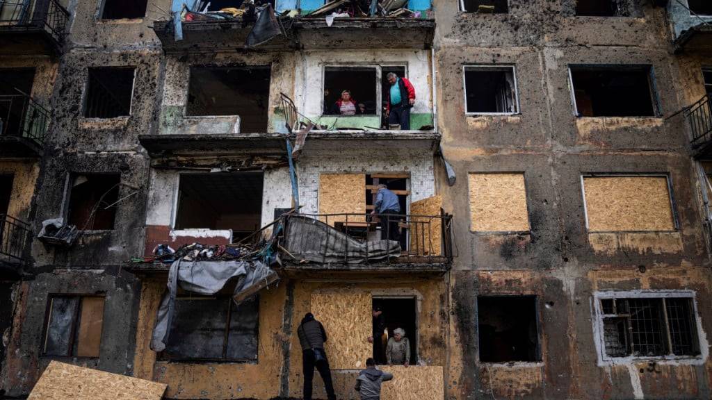 ARCHIV - Anwohner schließen die Fenster eines Wohnhauses mit Sperrholz nach russischem Beschuss in Dobropillja in der Region Donezk in der Ostukraine. Foto: Evgeniy Maloletka/AP/dpa