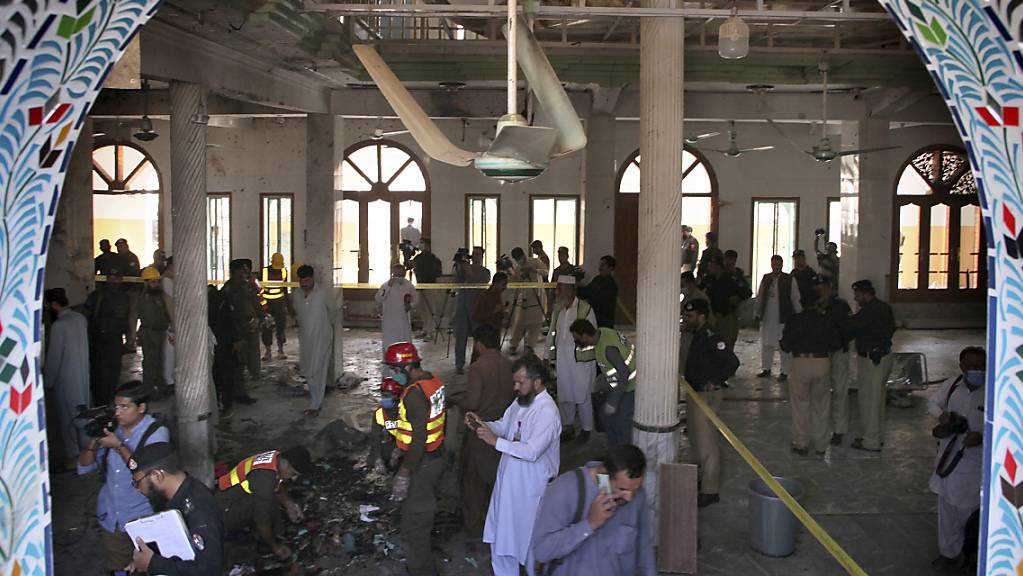 Rettungshelfer und Polizisten inspizieren den Ort in einer Koranschule, in der eine Explosion stattgefunden hat. Dabei sollen auch Kinder getötet und viele weitere Menschen verletzt worden sein.