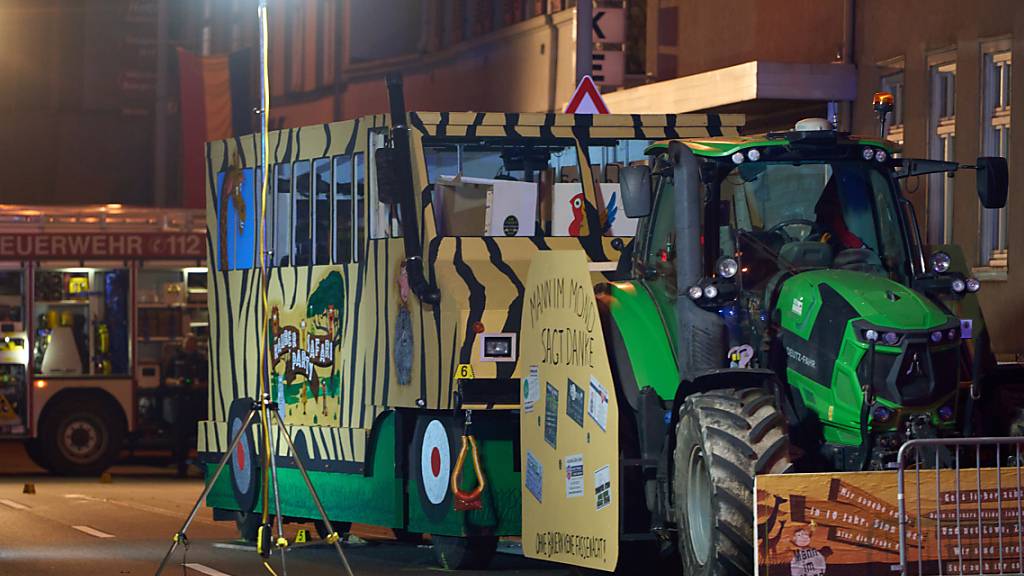 Polizeibeamte sichern Spuren an einem Karnevalswagen, nachdem ein Fußgänger überrollt worden war. Der junge Mann aus dem Rhein-Lahn-Kreis erlag im Krankenhaus seinen Verletzungen. Foto: Thomas Frey/dpa