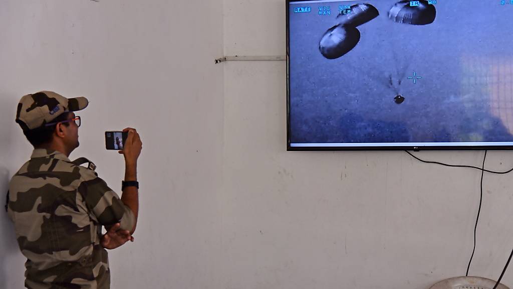 Indien hat erfolgreich eine Rakete für seine geplante bemannte Raumfahrtmission getestet. Ein Polizist betrachtet den Raketenstart.