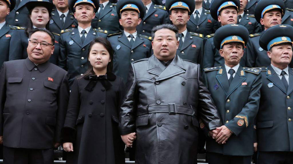 HANDOUT - Kim Jong Un, Machthaber von Nordkorea, neben seiner Tochter Ju Ae bei einem Fototerminin der Nationalen Behörde für Luft- und Raumfahrttechnik mit einer Gruppe von Ingenieuren und Wissenschaftlern, die nach eigenen Angaben zum erfolgreichen Start eines  militärischen Aufklärungssatelliten beigetragen haben. Foto: Uncredited/KCNA/KNS/dpa - ACHTUNG: Nur zur redaktionellen Verwendung und nur mit vollständiger Nennung des vorstehenden Credits