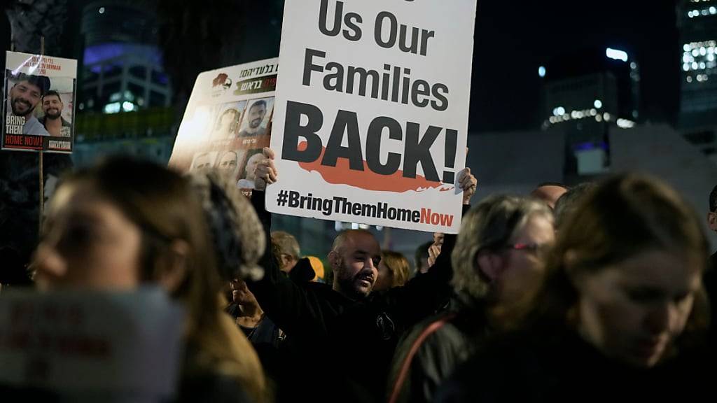 dpatopbilder - Ein Mann hält während einer Demonstration ein Plakat, auf dem die Freilassung der von Hamas-Kämpfern entführten Geiseln im Gazastreifen gefordert wird. Foto: Leo Correa/AP