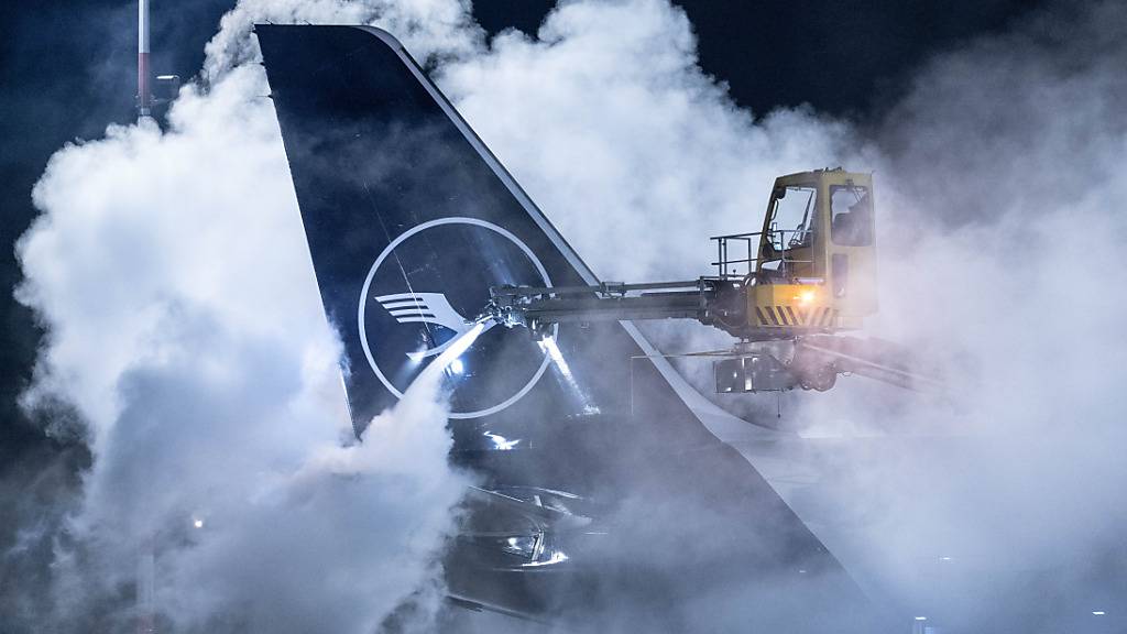 dpatopbilder - Eine Lufthansa-Maschine wird auf dem Flughafen Frankfurt enteist. Angesichts der Wetterlage hat der Flughafen den Flugplan zusammengestrichen. Foto: Boris Roessler/dpa