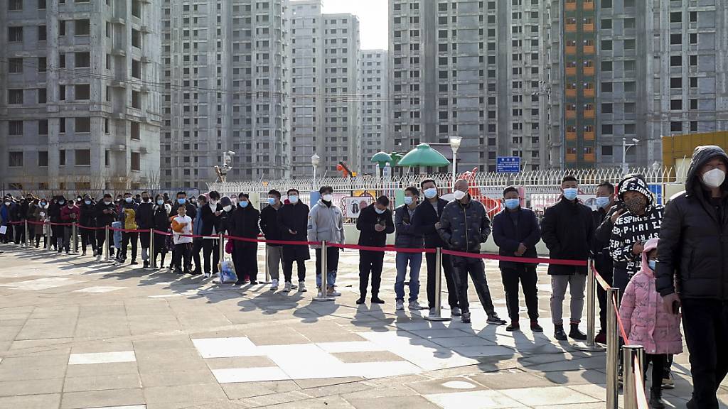 dpatopbilder - Einwohner warten in Tianjin auf ihren Coronavirus-Test. Die nordostchinesische Stadt Tianjin hat nach dem Auftreten der ersten lokalen Omikron-Fälle Massentests angeordnet. Wie die Behörden am Sonntag mitteilten, wurden in der Stadt seit Freitag 20 Corona-Infektionen identifiziert. Foto: Uncredited/CHINATOPIX/AP/dpa