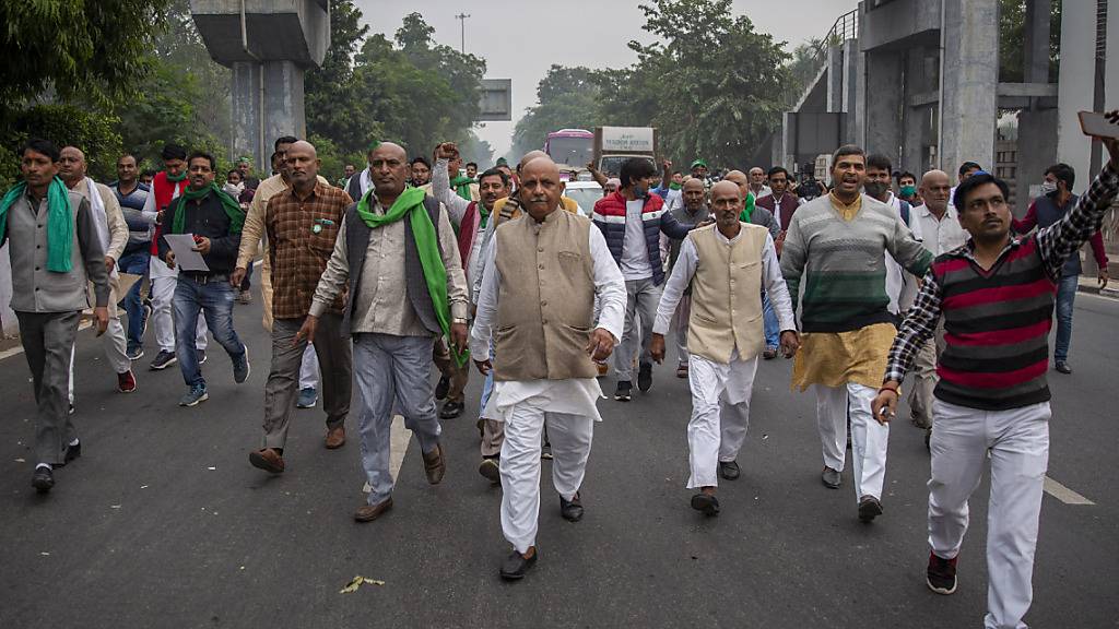 Eine Gruppe indischer Bauern protestiert auf dem Weg zum Wohnsitz des regierenden Mahesh Sharma der Bhartiya Janata Partei. Indische Bauern reichten beim Obersten Gerichtshof eine Petition ein, in der sie die Aufhebung von drei neuen Gesetzen zur Agrarreform fordern. Foto: Altaf Qadri/AP/dpa