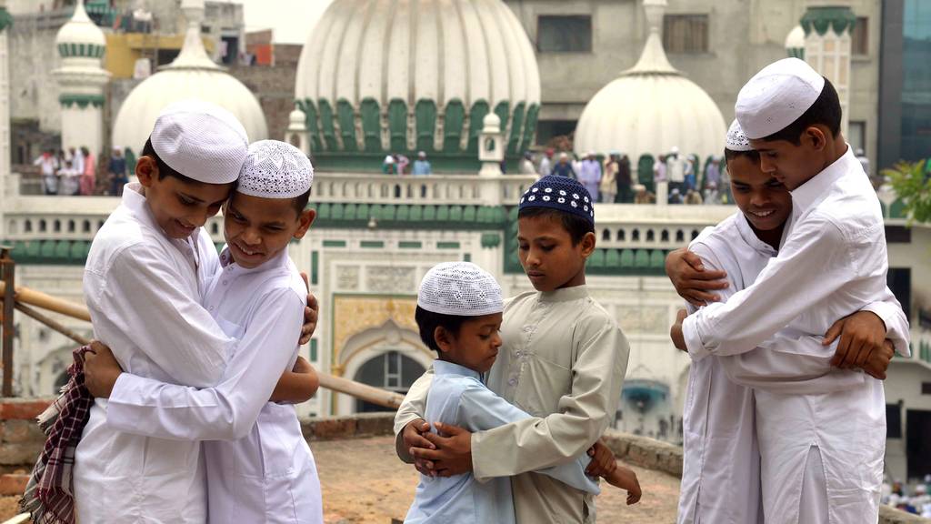 Indische Muslime umarmen sich nach dem Eid-Gebet anlässlich des Eid al-Fitr-Festes, das das Ende des heiligen Monats Ramadan markiert