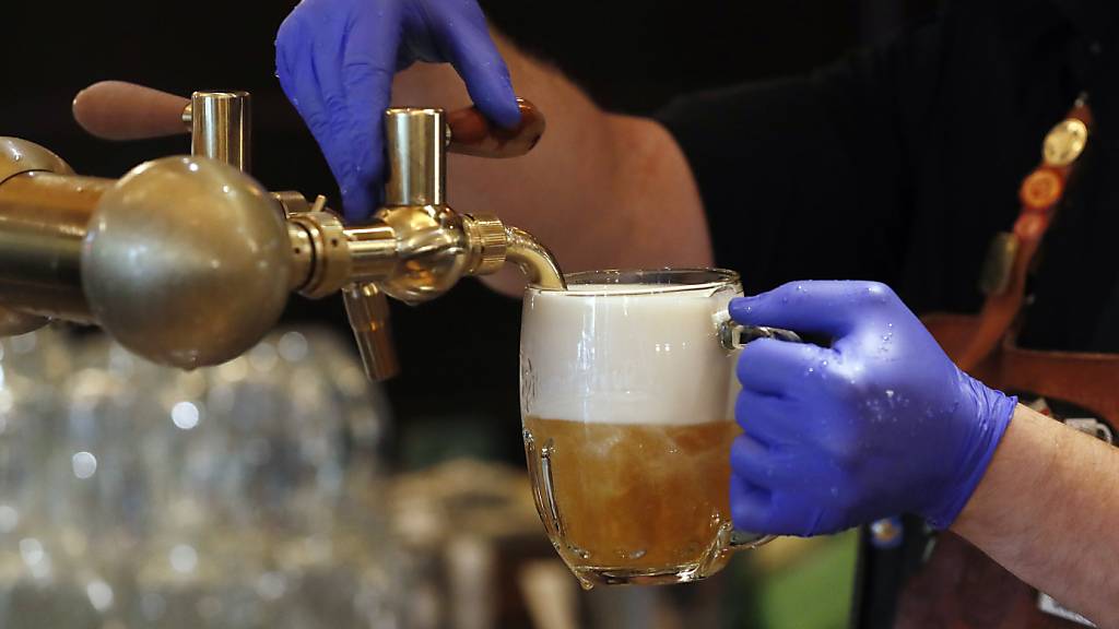 ARCHIV - Ein Barkeeper zapft ein Bier auf einer Restaurant-Terrasse. Foto: Petr David Josek/AP/dpa