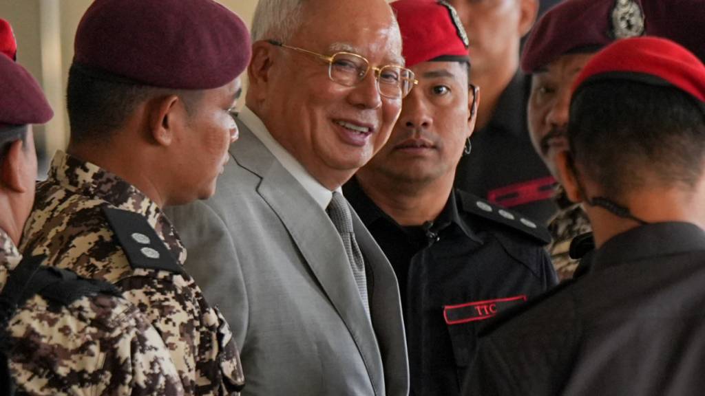 ARCHIV - Der ehemalige malaysische Premierminister Najib Razak, Mitte, wird bei seiner Ankunft im Kuala Lumpur High Court Complex von Gefängnisbeamten eskortiert. Foto: Azneal Ishak/AP/dpa