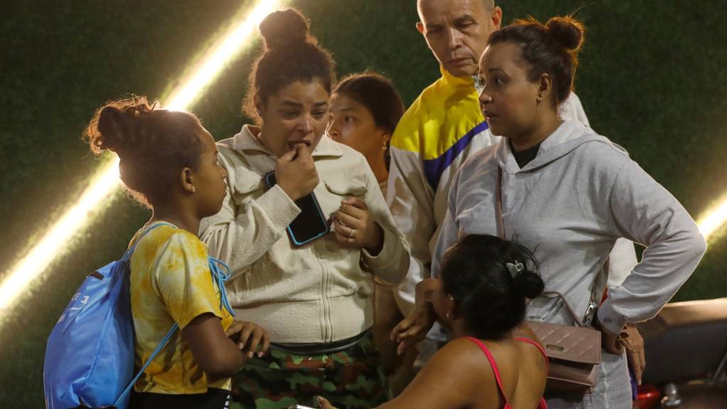 Anwohner aus einem Gebäude, das evakuiert wurde, stehen in der Nähe des Präsidentenpalastes Miraflores, nachdem Explosionen und tieffliegende Flugzeuge in Caracas, Venezuela, am Samstag, 3. Januar 2026, zu hören waren. Foto: Cristian Hernandez/AP/dpa