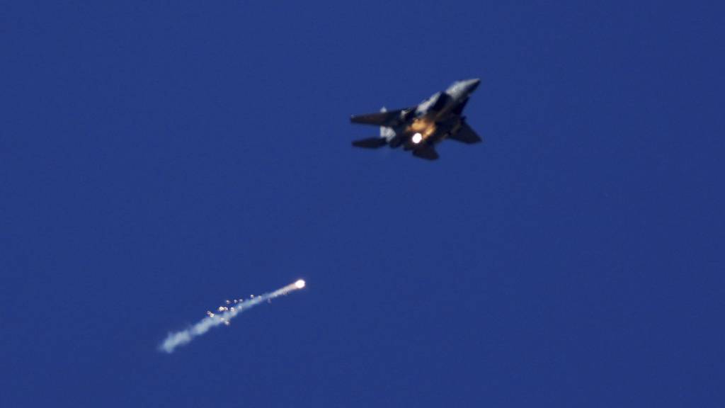 ARCHIV - Ein Kampfflugzeug der israelischen Luftwaffe feuert Leuchtraketen über dem Gazastreifen ab, zu sehen vom Süden Israels aus. Foto: Ariel Schalit/AP/dpa