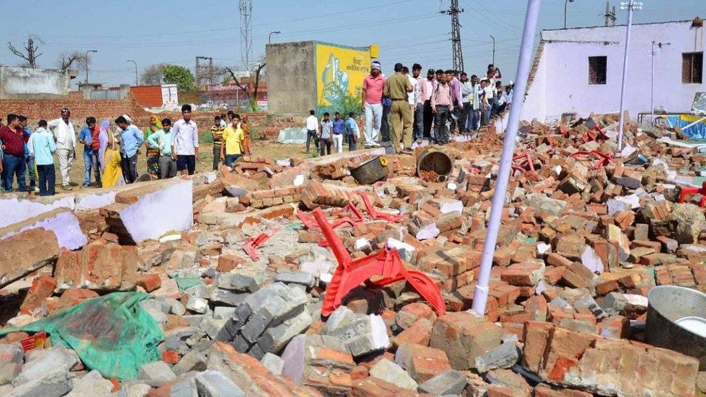 Plastikstühle ragen aus den Trümmern nach dem Einsturz der Mauer.