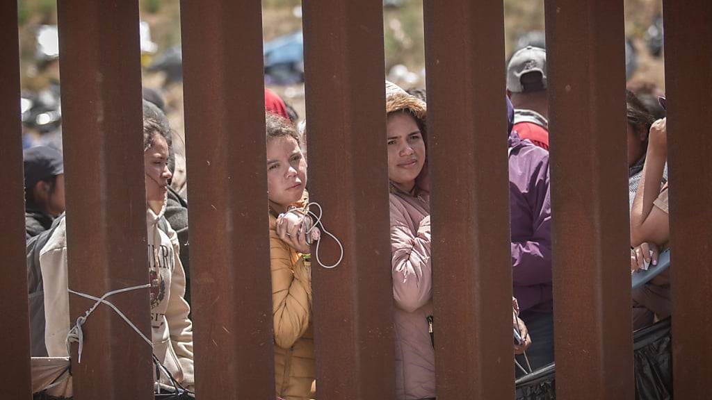 ARCHIV - Frauen stehen hinter der Grenzmauer zwischen Mexiko und USA und hoffen darauf, in die USA einreisen zu können. Foto: Antonio Castaneda/dpa