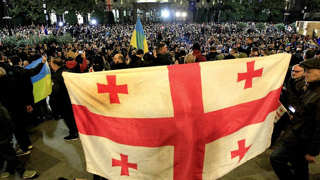 Ein Demonstrant hält eine georgische Flagge während einer Protestaktion der Opposition gegen die Ergebnisse der Parlamentswahlen. Foto: Shakh Aivazov/AP