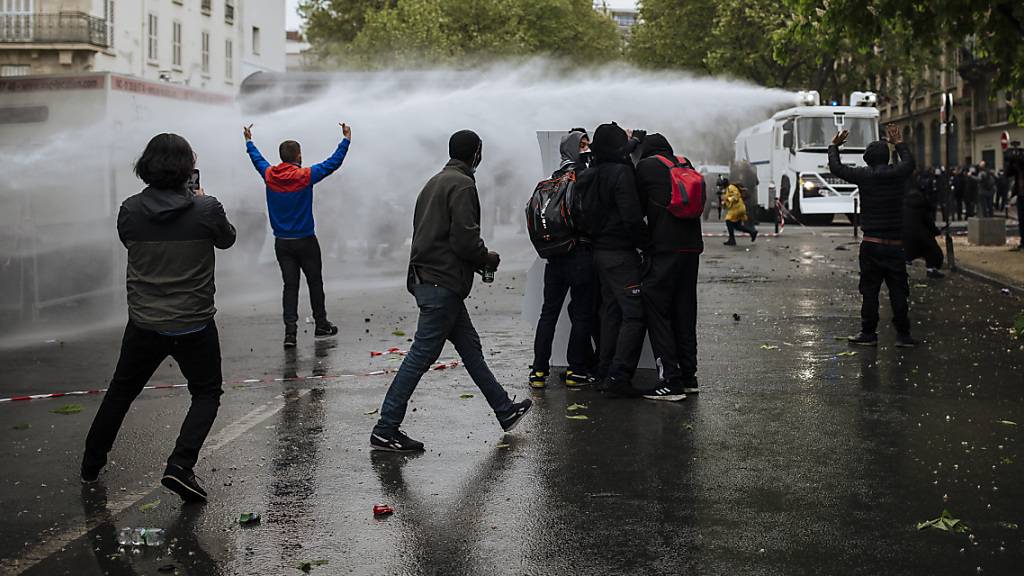Polizisten setzen einen Wasserwerfer gegen Demonstranten auf dem Place de la Nation ein. Foto: Lewis Joly/AP/dpa