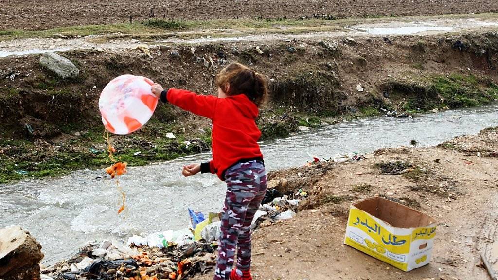 Ein syrisches Mädchen wirft in einem Flüchtlingslager im Libanon Abfall weg. (Archiv)