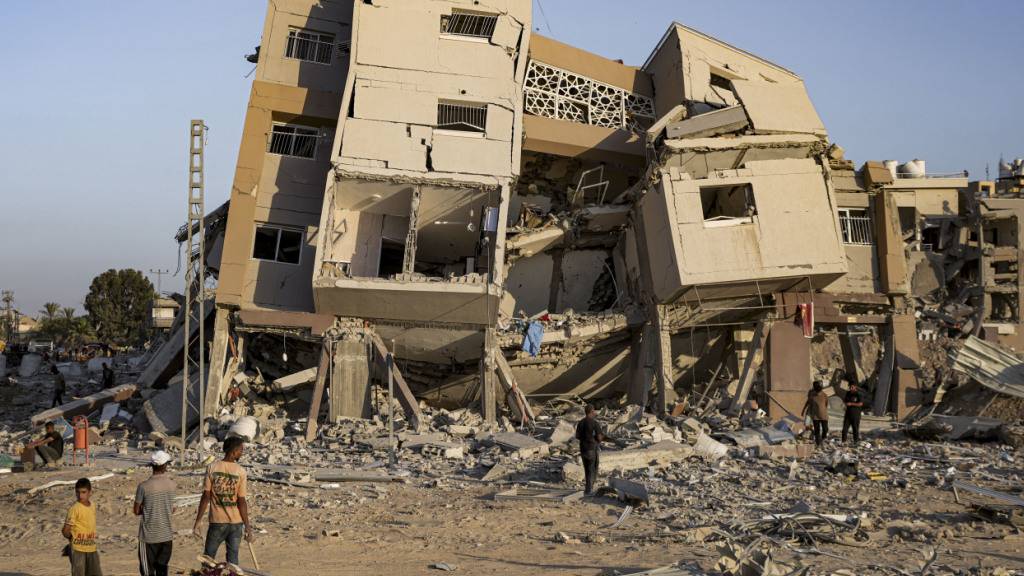 ARCHIV - Palästinenser inspizieren ihre Häuser, nachdem sie durch israelischen Beschuss östlich von Deir al-Balah zerstört wurden. Foto: Abdel Kareem Hana/AP/dpa