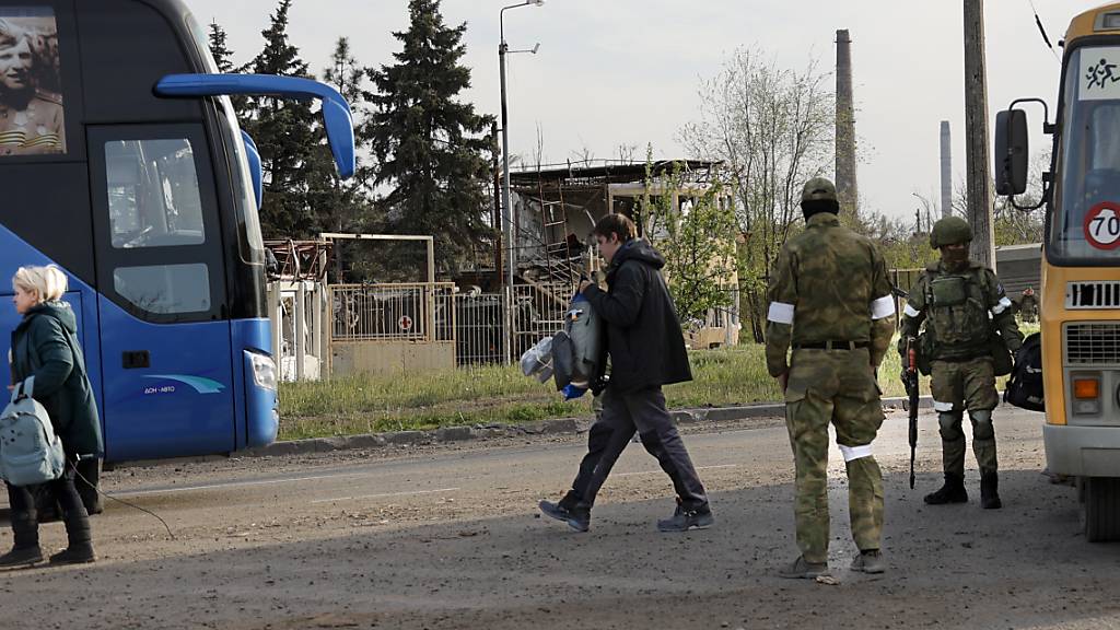 Menschen, die ihren Unterschlupf im Stahlwerk Asovstal in Mairupol verlassen haben, gehen zu einem Bus. Foto: Alexei Alexandrov/AP/dpa