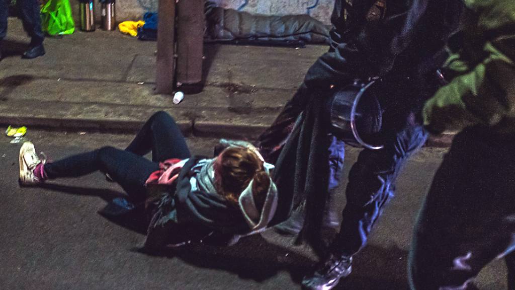 Ein Polizist zerrt eine Demonstrantin von der Straße. Foto: Christopher Glanzl/APA/dpa